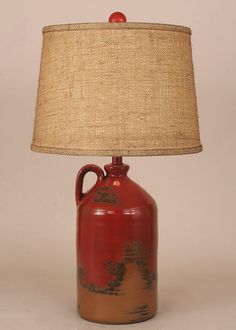 a red vase with a brown base and a beige shade on the top is sitting in front of a white background