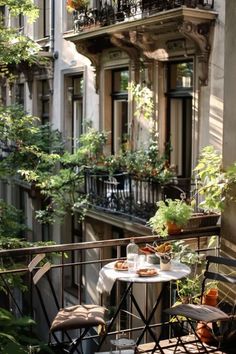 an apartment balcony with tables and chairs, potted plants on the balconies