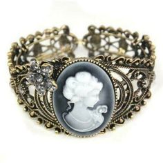 Victorian Steampunk Antiqued Brass Cameo Filigree Cuff Bracelet Features A Resin Cameo Focal Point Oval Shaped Cameo Is Off White On Shades Of Grey Pearl To Charcoal Antiqued Brass Cuff Has Elastic Backing That Allows For Easy On And Off Fits Any Woman's Wrist Well Accented With Rhinestone Flower Perfect For Victorian Or Steampunk Styling Cameo Bracelet, Cameo Jewelry, Victorian Steampunk, Vintage Cameo, Evening Dress Fashion, Moda Vintage, Cuff Bangles, Vintage Bracelets, Mode Vintage