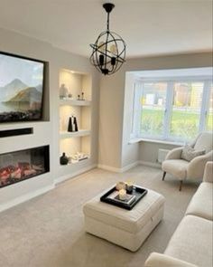 a living room filled with furniture and a flat screen tv mounted on the wall above a fireplace