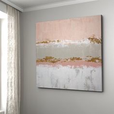 an abstract painting hangs on the wall next to a window with drapes and curtains