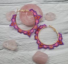 Handmade beaded hoop earrings with a unique tribal shape, these earrings feature a unique shape with a multicolored pattern inside. They were inspired by the shapes seen in art and architecture of Mesoamerican civilizations and the beautiful hot pink Frangipani flowers that grow there. They are another addition to the Daughters of collection. These hoops are depicted in a vibrant pink and purple motif but can be custom ordered in many colors. Alternate sizes can also be custom ordered. Feel free Traditional Handmade Adjustable Hoop Earrings, Handmade Adjustable Traditional Hoop Earrings, Unique Handmade Geometric Earrings, Bohemian Handmade Round Hoop Earrings, Handmade Bohemian Round Hoop Earrings, Handmade Multicolor Small Hoop Jewelry, Bohemian Purple Round Hoop Earrings, Purple Bohemian Round Hoop Earrings, Unique Multicolor Small Hoop Earrings