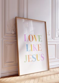 a framed poster with the words love like jesus in multicolored letters on it