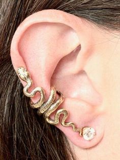 This Snake Ear Cuff is cast in solid 14K gold. The graceful snake wraps playfully along the edge of the ear. It can be worn on either the left or the right ear. (Diamond not included.)Our ear cuffs require no piercings. Starting near the top of the ear, slide the ear cuff down along the edge of the ear's cartilage. You may gently open or close the opening of the ear cuff to accommodate the thickness of your ear.This item usually ships the same or next business day.All Marty Magic Jewelry is pack Snake Ear Cuff, Jóias Body Chains, Serpent Jewelry, Snake Ears, Ear Cuff Jewelry, Wrap Earrings, Bar Stud Earrings, Snake Jewelry, Cuff Jewelry