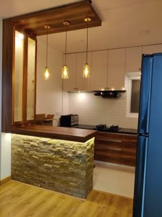 a kitchen with wood flooring and white walls next to a blue refrigerator freezer