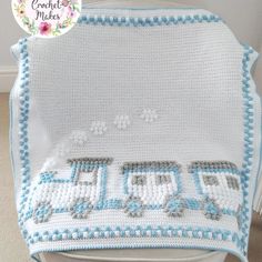 a crocheted blanket that is sitting on top of a white chair with blue trim