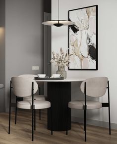 a dining room table with two chairs and a painting on the wall