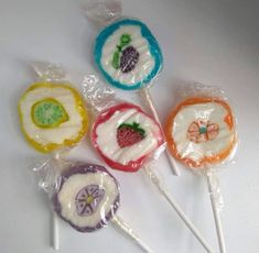 four lollipops with designs on them in plastic wrappers