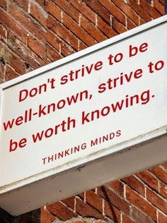 a sign on the side of a brick building saying don't strike to be well - known, strive to be worth kw