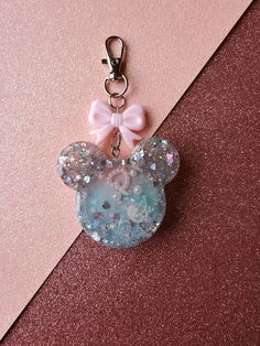 a keychain with a minnie mouse charm attached to it's side on a pink background