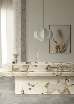 a bathroom with marble counter tops and white walls, along with a painting on the wall