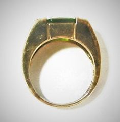 Wide gilt silver band with square green stone, silver sections on each side with what appear to be diamond chips. Measures slightly under a size 6 (between 5 3/4 and 6 on ring sizer). The stone is a yellowish green, possibly a peridot, but could be a synthetic stone. It is signed 925 with an initial on one side of the interior band, and China on the other side. Some light tarnish visible, several of the small chips on the side are missing (so small a loup is necessary to see them). The stone has Modern Green Jewelry With Accent Stones, Modern Green Rings With Prong Setting, Modern Green Jewelry With Prong Setting, Modern Green Emerald Ring With Accent Stones, Modern Green Ring With Rectangular Stone, Formal Green Emerald Ring With Rectangular Stone, Formal Rectangular Green Emerald Ring, Modern Green Rectangular Stone Ring, Green Ring With Rectangular Stone In Prong Setting