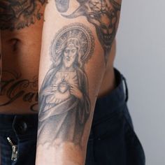 a man with tattoos on his arm holding a cell phone