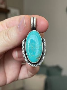 "This turquoise is a beautiful island blue.  I set her in a straight fine silver bezel and gave her a sterling zig zag accent wire that I just can't get enough of!!  She has been oxidized to bring out the details and give her a rustic vintage feel. Measurements:  1.8\" x .9\" Comes on a 20\" sterling silver adjustable chain. Turquoise's properties are water-like and can instill a sense of calm within you. It has been celebrated over time as a stone of protection and tranquility.  One of the turquoise's meanings is that of new beginnings and restoring your well-being. When you purchase from Crimson Buffalo you are getting a one-of-a-kind hand- crafted piece of jewelry.  We do not use molds so no two pieces will ever be identical; each will have its own character and markings making them uni Artisan Blue Turquoise Necklace Untreated, Untreated Turquoise Pendant Jewelry, Handmade Blue Turquoise Necklace Collectible, Handmade Blue Turquoise Necklace For Collectors, Handmade Blue Turquoise Collectible Necklace, Bohemian Turquoise Necklace With Large Sterling Silver Stone, Bohemian Oval Turquoise Necklace Stamped 925, Bohemian Turquoise Oval Pendant Jewelry, Unique Turquoise Necklace Stamped 925