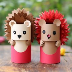 two paper toy hedgehogs sitting next to each other on top of a wooden table