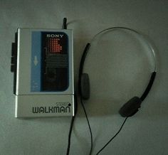 a sony walkman with headphones is laying on the floor