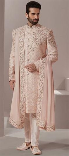 a man in a white sherwa with a pink shawl