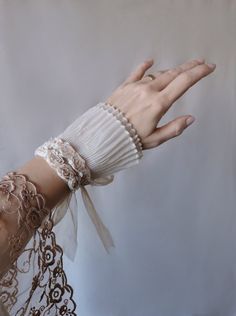 You can purchase 2 pcs for a beautiful pair.  Adorn your bridal ensemble with the timeless elegance of this Ecru Beige Roses Wrist Cuff. Perfect for a vintage-inspired wedding look that exudes Victorian charm and sophistication. A beautiful gift for bridesmaid, bridal party or for any bride seeking a touch of romance on her special day.  ♥ Materials: one size soft tulle fabric wrist cuff, handmade roses, layered tulle. All pieces are hand sewn. It's adjustable with tulle ribbons at the back - see the picture below. One size fits all. Unique art cuff. Ready to ship! All my designs are one of a kind and completely handmade - a guarantee that you would be exceptional and unique in the whole world. ✂ Sizing ✂ ♥  You can approximate the proportions by viewing the photos or you can use a tape fo Elegant Beige Bracelet For Formal Occasions, Elegant Beige Bracelets For Formal Occasions, Adjustable Bridal Accessories For Ceremony, Elegant Beige Wedding Jewelry, Adjustable Cream Bridal Accessories As Gift, Elegant Formal Wristlet, Elegant Beige Bracelets For Parties, Adjustable Cream Bracelet For Wedding, Elegant Adjustable Bridal Accessories For Marriage