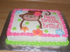 a birthday cake decorated with a monkey and flowers