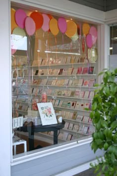 a store front with balloons and cards in the window