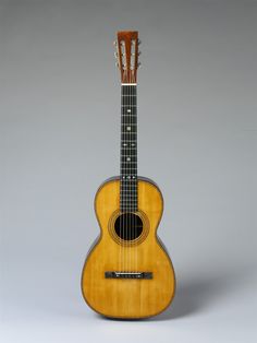 an acoustic guitar is shown on a gray background