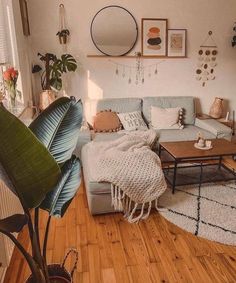 a living room filled with furniture and lots of greenery on the wall next to a window