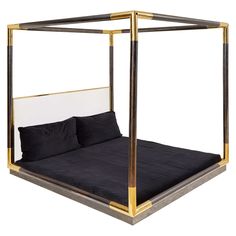 a four poster bed with black sheets and gold trim