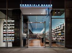 the entrance to a book store with many books on display in glass windows and lit up shelves