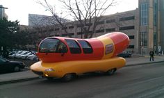 a very large hot dog car on the street