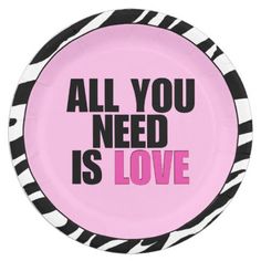 a pink plate with black and white stripes on it that says, all you need is love