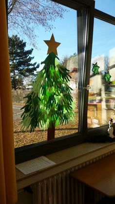 a small christmas tree sitting on top of a window sill