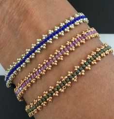 three different bracelets on someone's arm, one with beads and the other with flowers