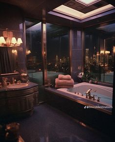 a bathroom with a large bathtub next to a window overlooking the city at night