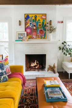 a living room filled with furniture and a fire place under a painting on the wall