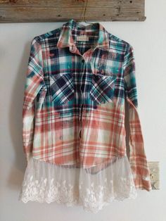 a plaid shirt hanging on the wall with lace trimmings and an old wooden hanger