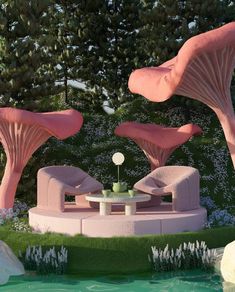 two pink mushrooms sitting on top of a lush green field next to a pond with water