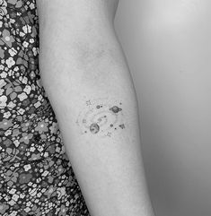 a woman's arm with an inked space themed tattoo on the left inner arm