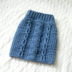 a blue knitted hat sitting on top of a bed