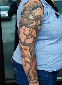 a woman with a tree tattoo on her arm