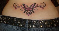 a woman's stomach with a butterfly tattoo on her belly and pink flowers in the center