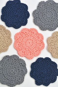 crocheted coasters are arranged on a white surface with different colors and sizes