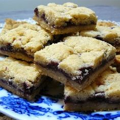 a blue and white plate topped with chocolate crumbs cookie bars on top of each other