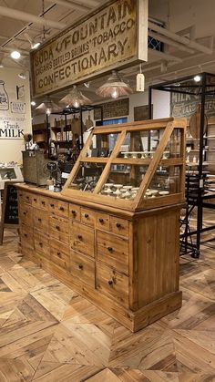 a store with wooden furniture and signs hanging from the ceiling in it's center