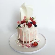 a strawberry cake with white frosting and strawberries on top