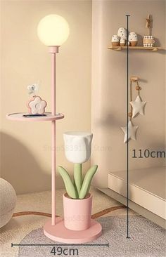 a pink table with a light on top and a plant in the corner next to it