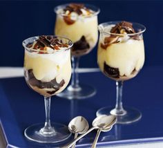 three glasses filled with dessert sitting on top of a blue tray