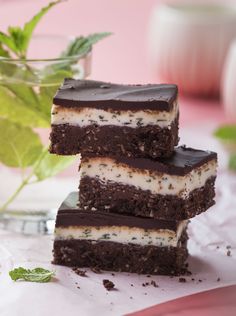 three pieces of cake sitting on top of a table next to a glass of water