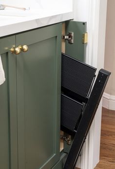 an open drawer in the middle of a kitchen cabinet with a sink and countertop