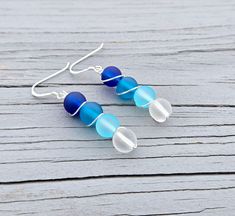 These sterling silver earrings make a great gift!  Each one has 4 sea glass beads in dark blue, turquoise, light blue, and white. These earring hooks and wire are sterling silver. The beads each measure 8mm in diameter.  Total length of the earrings: 1 7/8" Bead length: 1 1/4" This would be a great gift for any time of the year! Perfect for a wedding, for a Christmas gift, anniversary gift, or a birthday. All jewelry items come in a gift box. Please let me know if you have any questions. Sea Glass Earrings, Blue Ombre, Wire Earrings, Glass Earrings, Sterling Silver Earrings, Silver Earrings, Gifts For Women, Anniversary Gifts, Favorite Jewelry