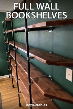 the shelves are lined up against the wall in the room with green walls and wood flooring